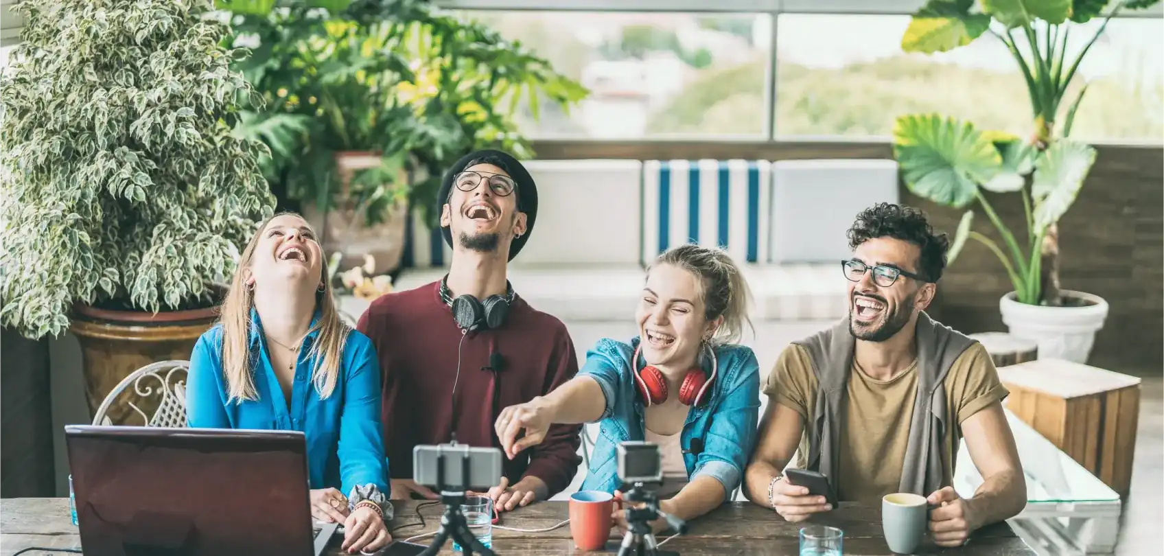 Group of young people sharing and laughing together while creating digital content in a relaxed and collaborative environment.